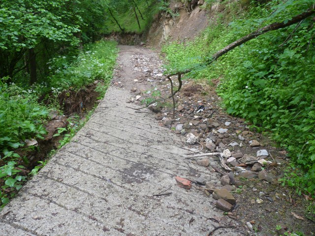 Camino de La Gatera, con las piedras arrastradas por la riega. A la izquierda se ve el socavón producido. Pulse para verlo más grande
